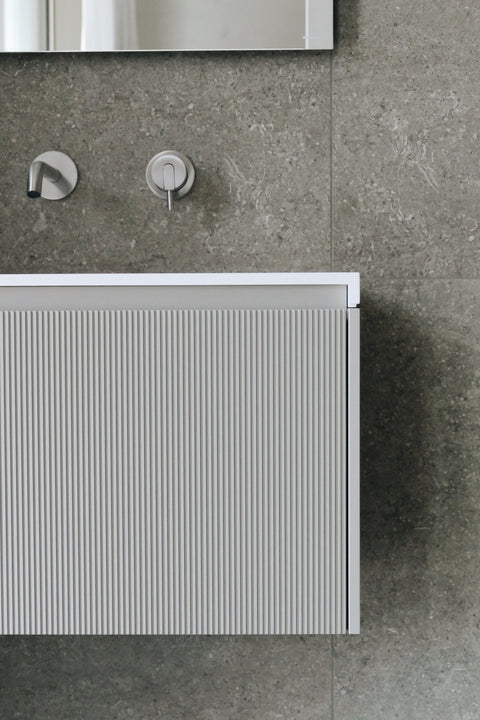 Designer large format tiles cladding a stylish bathroom wall